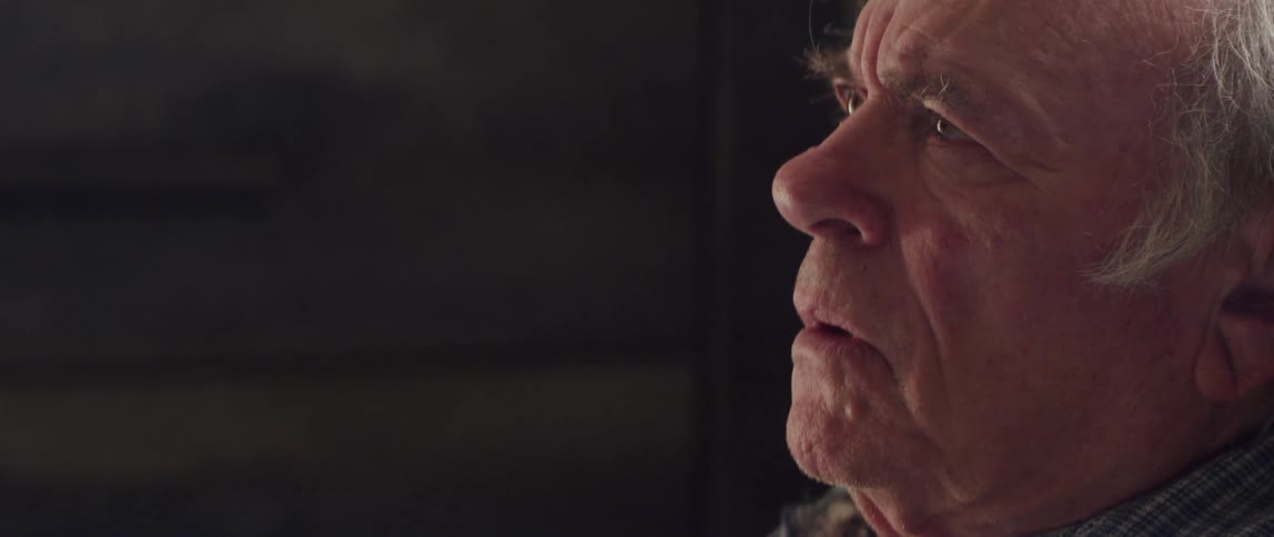 An elderly man reacts with fear and sadness during a conversation