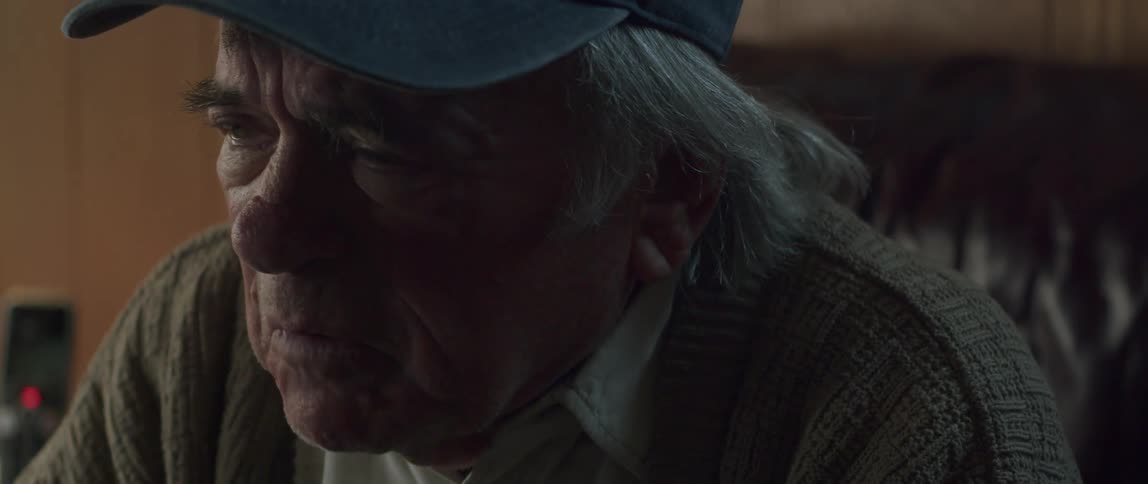 Portrait of an elderly man sitting with watery eyes and being sad