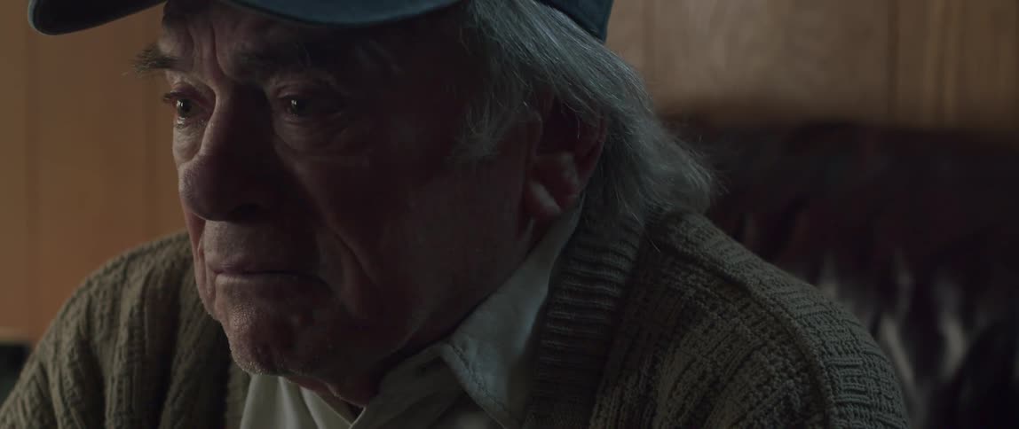 An elderly person speaks to someone and then he breaks down crying