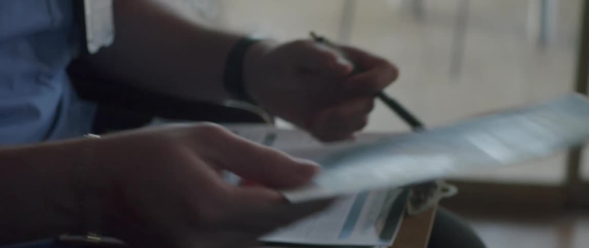 Person with clipboard hands medical care brochure to elderly person