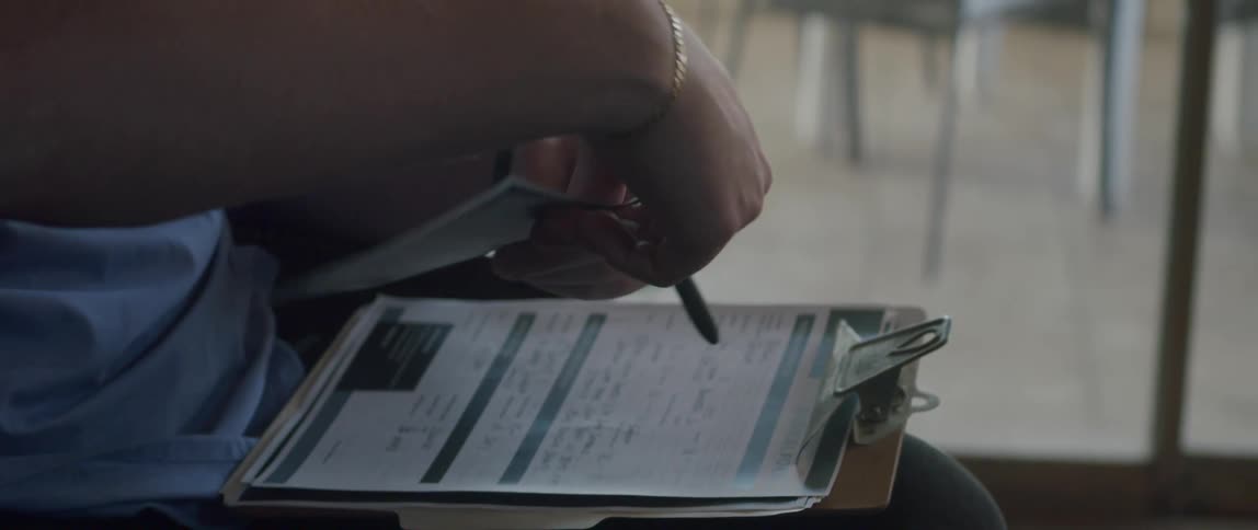 Close up of a male nurse handling a brochure to a patient
