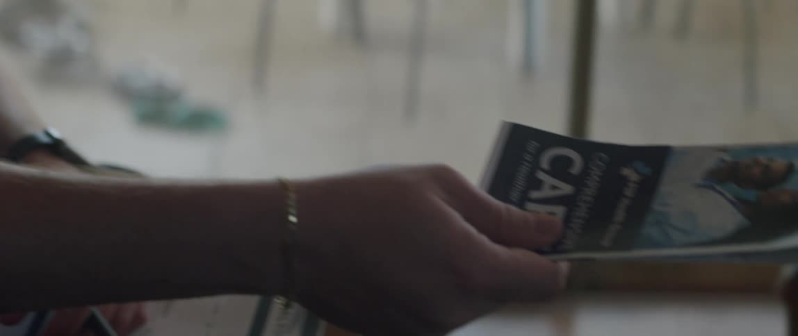 A healthcare worker hands a pamphlet to an elderly man