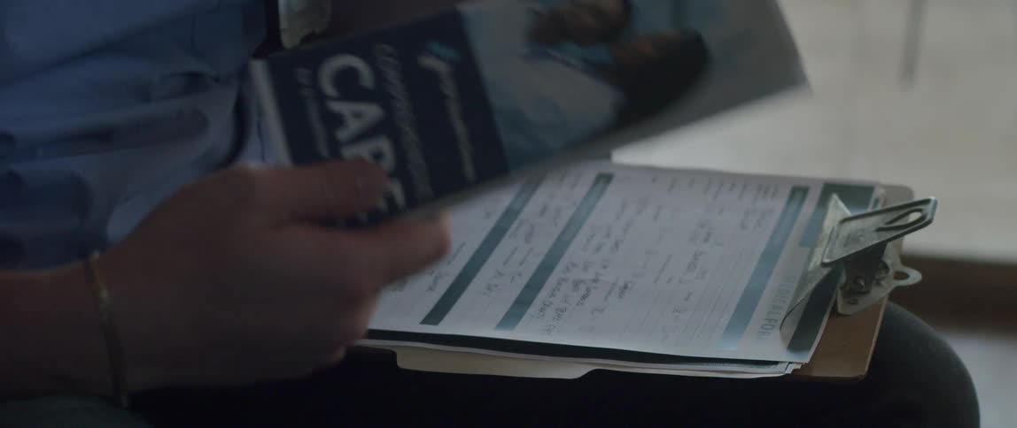 Hands of a doctor holding a pen and picking up a pamphlet gesturing