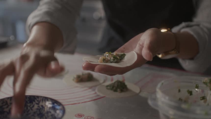 A woman prepares food on a table