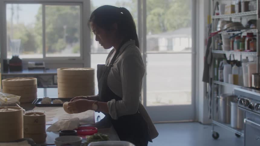 Woman prepares dough in a commercial kitchen