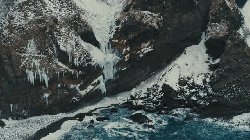 The mountains on the shore are covered in ice