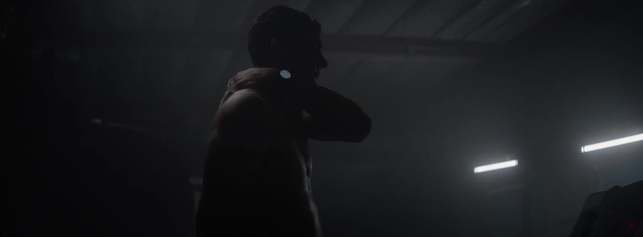 A man in a gym wipes sweat with a rag