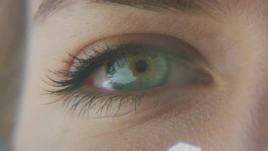 The green eye on the face of a person with fair skin