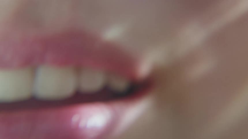 A woman smiles and closes her lips