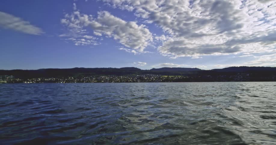A town in the distance on a lake with ripples on the surface