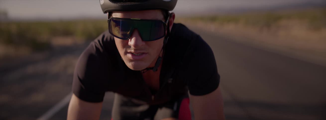 A person is riding a bicycle on a paved road on a rural area