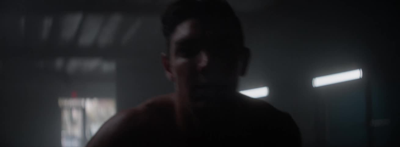 A man doing a cardio workout in a dark gym