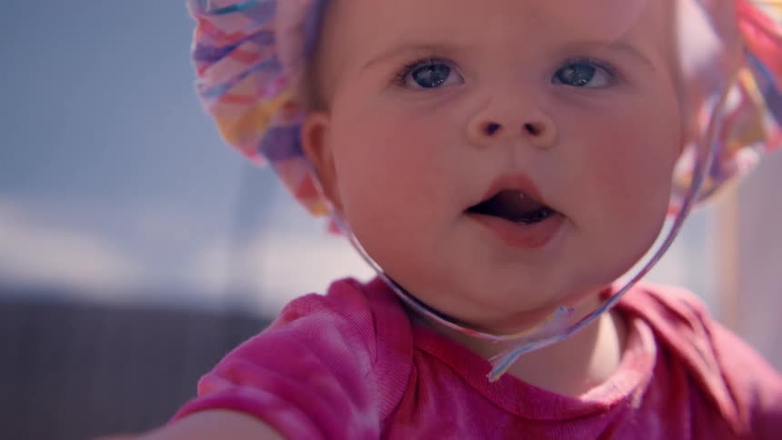 A baby lurches around outdoors