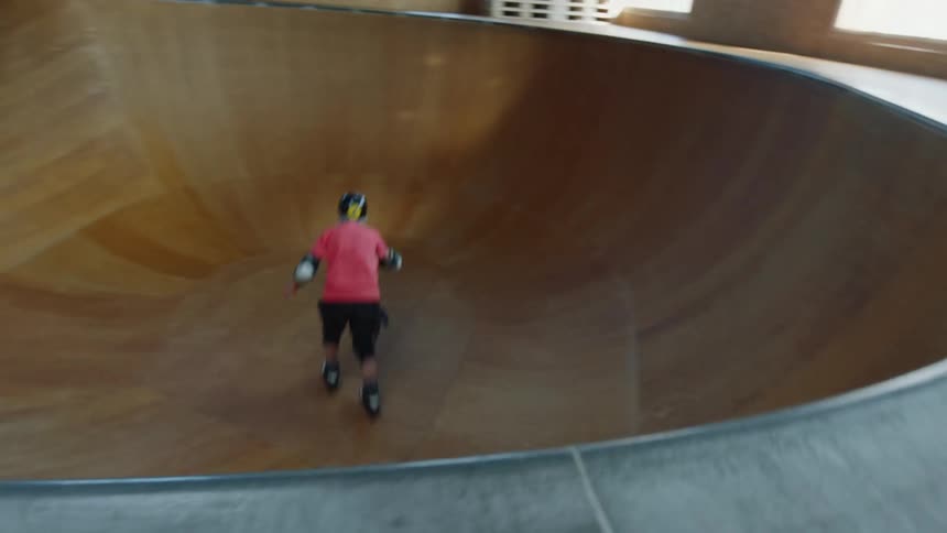 A skater rolling into an indoors skate park