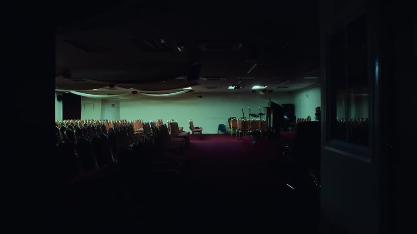 A chapel filled with chairs facing a podium on a small stage