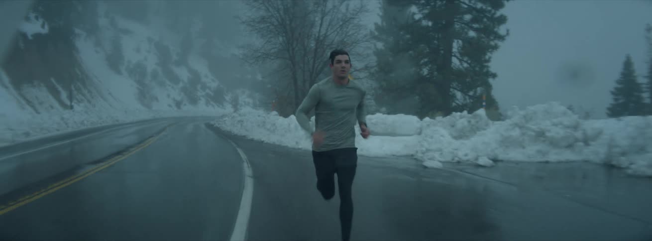 A man is running on the side of the road