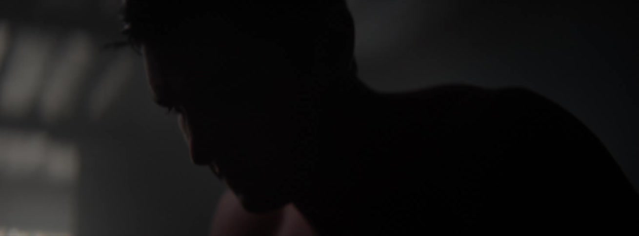 Close up of a man working out on a dark gym