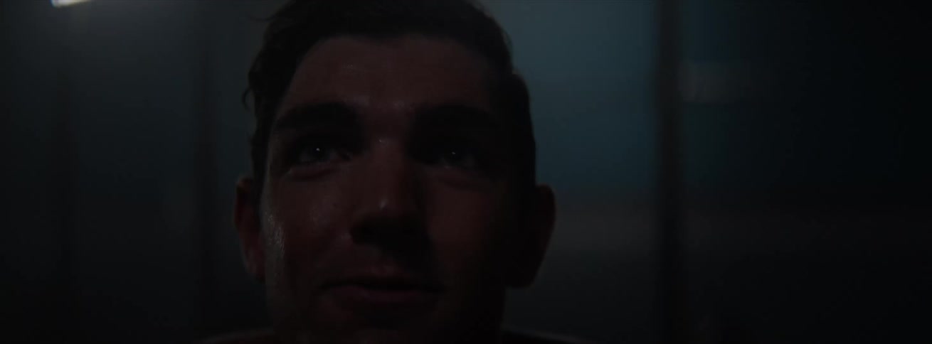 A man exercises on a dimly lit gym
