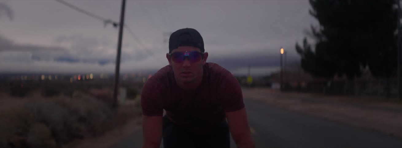 Cyclist rides up the road on a cloudy windy day