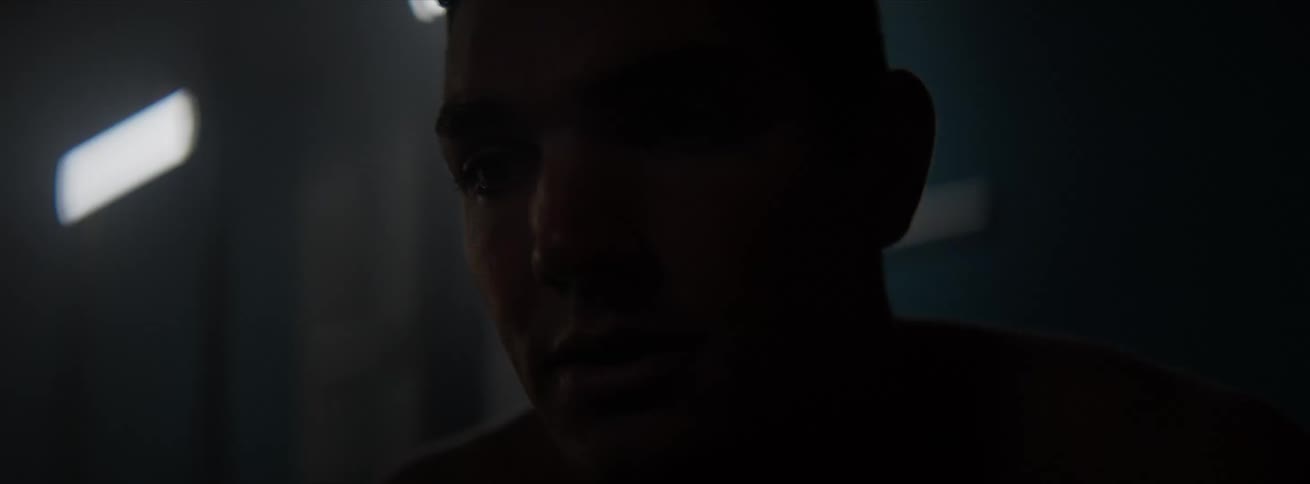 Close up of the face of a man on a dimly lit room