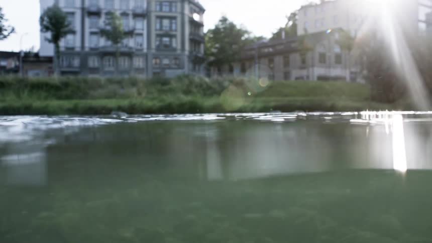 View from inside a crystal clear lake on the edge of a city