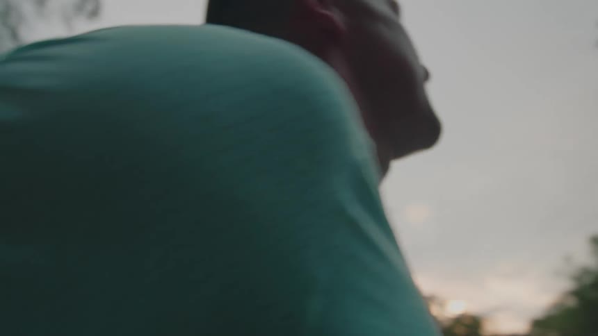 A jogger stops running to rest using his tshirt to clean the sweat off his face