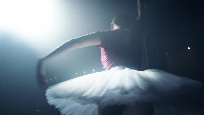 A female ballerina performs on stage