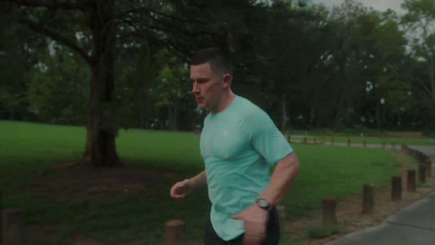 Concentrated and determined man running in a square with vegetation around