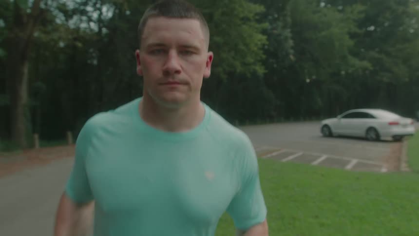 Man walking and then starting to run on a road with trees around