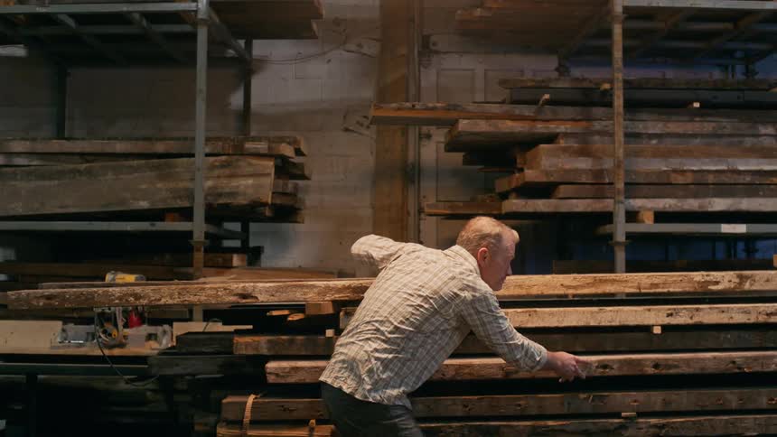 A clip of an old man inspecting some woods
