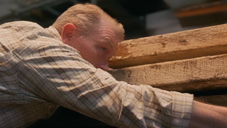 A man measures wood with his eyes