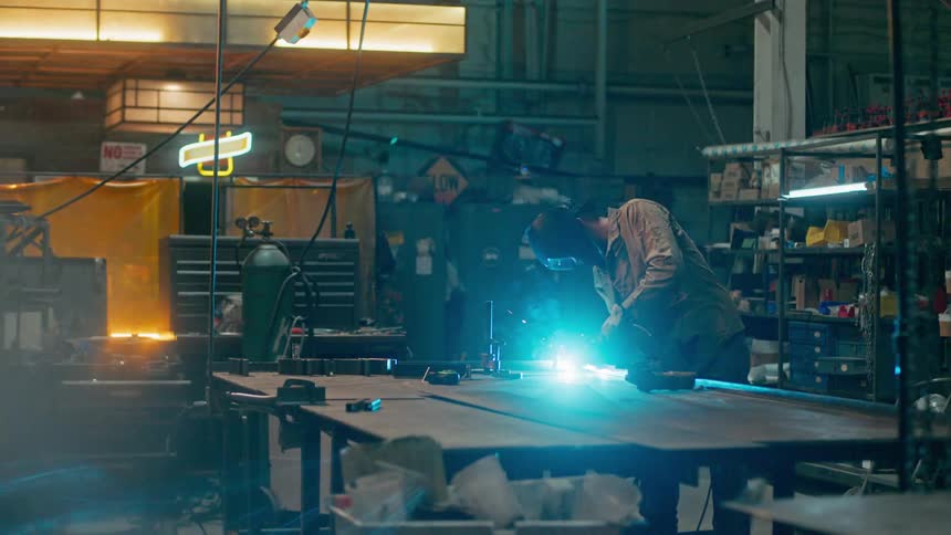 A welder is working in his shop