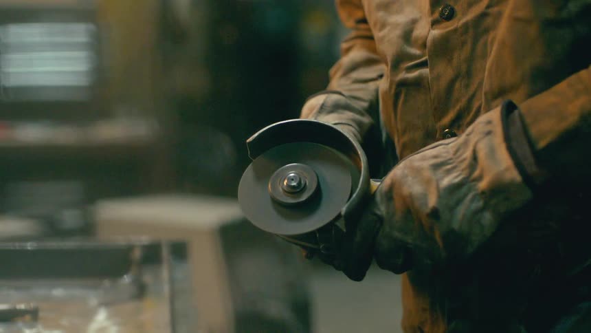 Worker in a workshop using a grinder