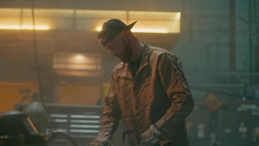 Man inside a factory placing a tool on a workbench