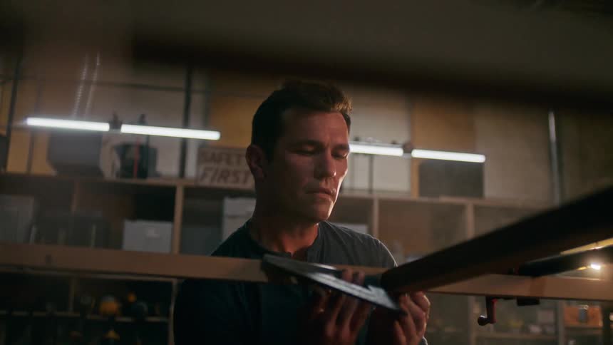 Carpenter checks for square at the joint of two wood slats