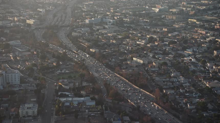 A massive amount of traffic is traveling on a major freewayin a large city