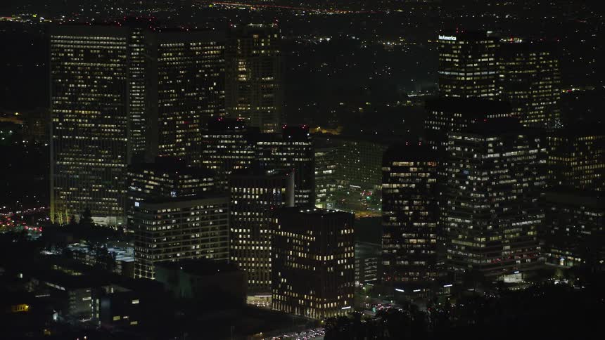 Lights glow on towers and skyscrapers overlooking the metropolitan city
