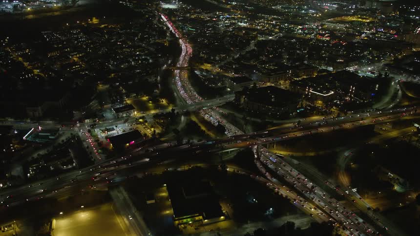 Aerial panorama of a highway at intersections in a metropolis illuminated at night with vehicle traffic