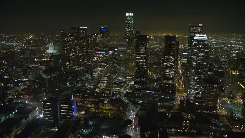 Numerous skyscrapers are illuminated against the night sky in los angeles