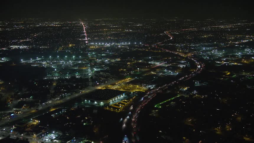 A nighttime aerial view of a city illuminated by lights
