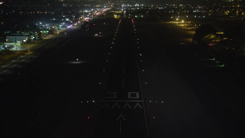 Point of view footage of a landing on an airport in the city at night
