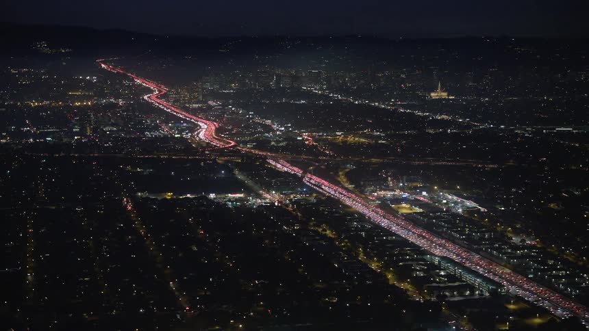 The freeway is brightly lit with heavy traffic
