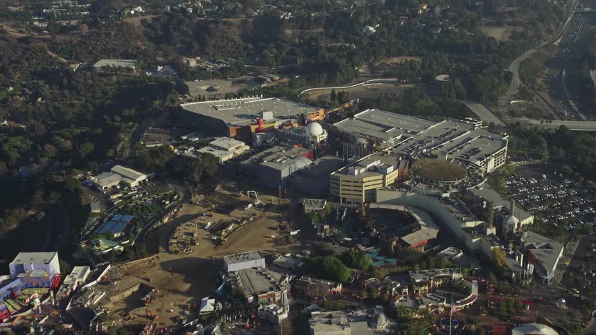 A large campus with distinctive buildings is located atop a hill