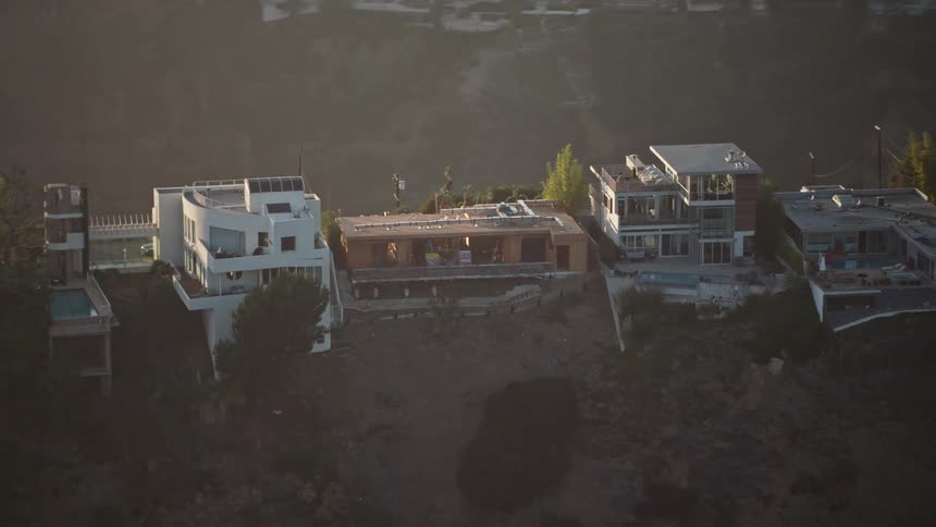 Mansions occupy ridge across foggy valley from residential neighborhood on the opposing slope