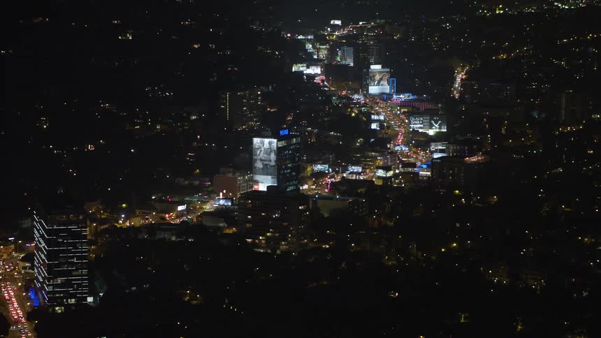 Aerial panorama of a metropolitan city with skyscrapers urban neighborhoods and vehicle traffic with its lights at night