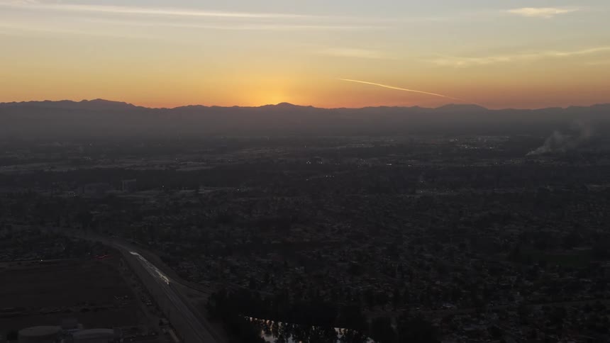 Aerial panorama of a residential city with a sun rising on the horizon