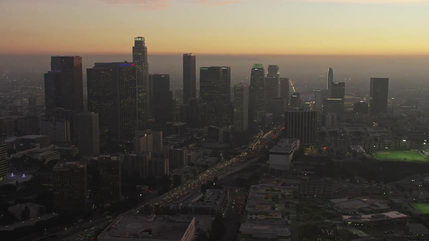 Aerial panorama of a metropolis with skyscrapers urban areas fields in a late afternoon with its orange