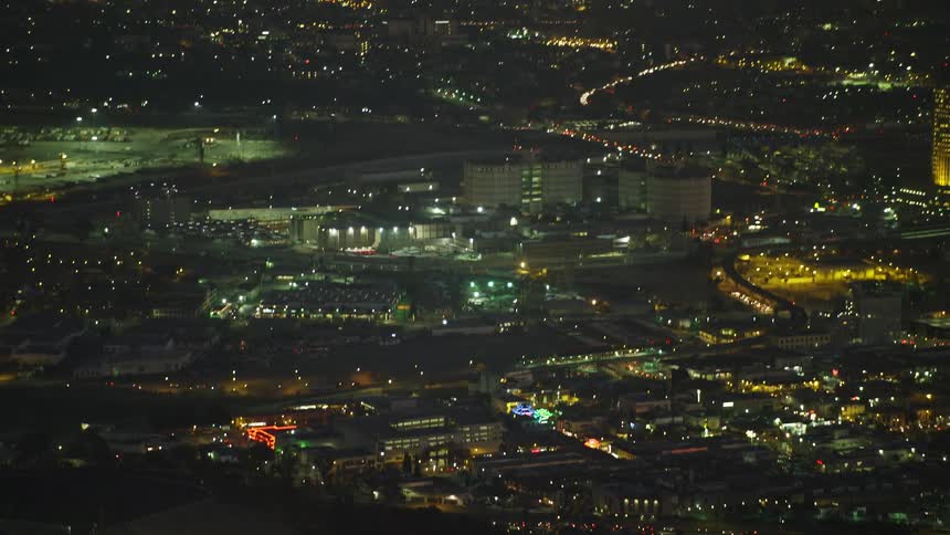 A helicopter flies over a large city at night