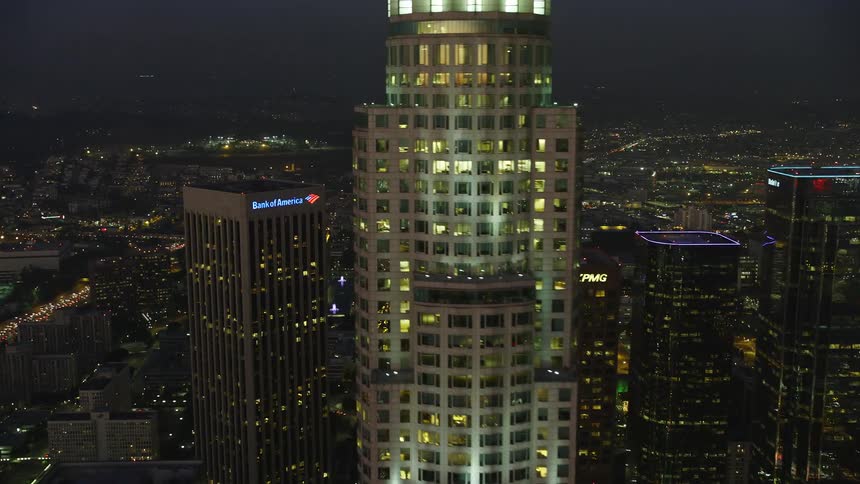 Aerial panorama of a metropolis with a skyscraper and commercial buildings in an illuminated night city