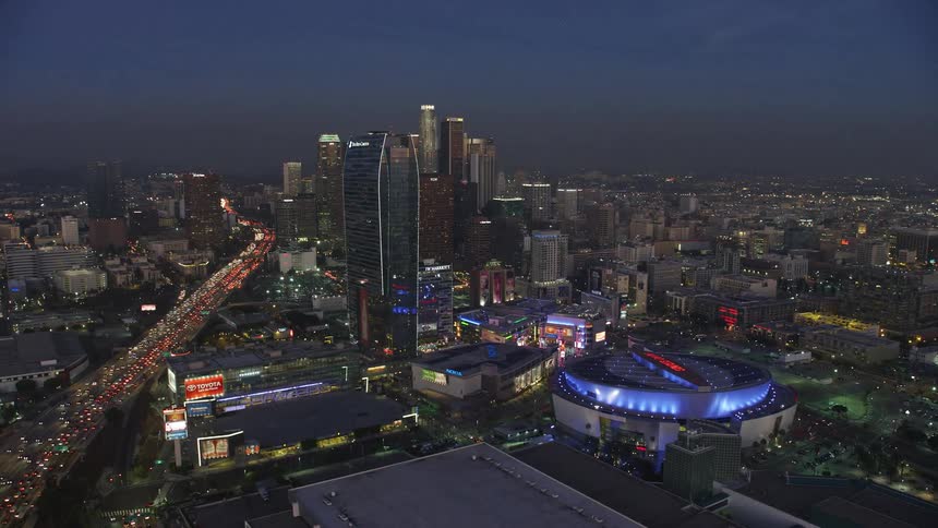 A skyscraper stands near a stadium in a city